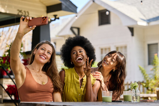 Friends Take Selfies at Outdoor Cafe