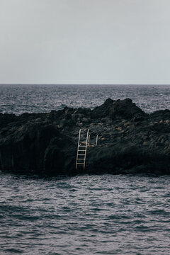 Solitary sea ladder on volcanic coast of La Palma island