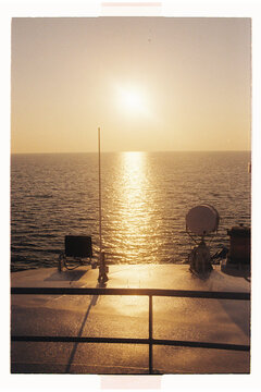 Sunset over ocean seen from ship deck