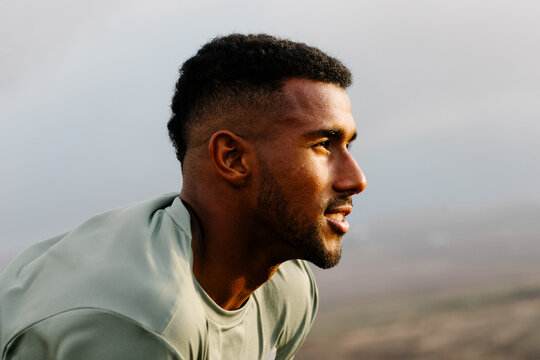 Athlete, crouching down to rest with an expression of satisfaction