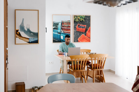 Wide view of an online business owner working from a dining room