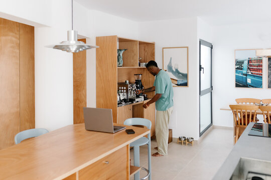 Modern man making himself a cup of coffee during a break while working