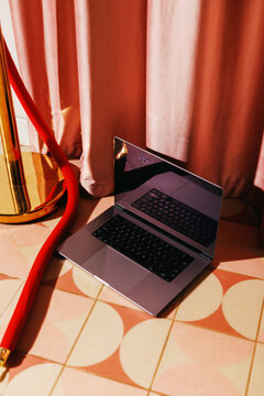 Laptop on Patterned Floor with Red Velvet Rope