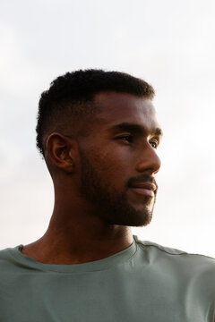 A headshot of a young Black man wearing a green T-shirt