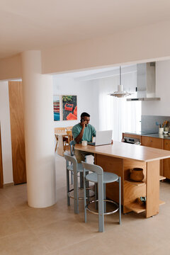 Freelancer makes business calls in the kitchen during a productive day