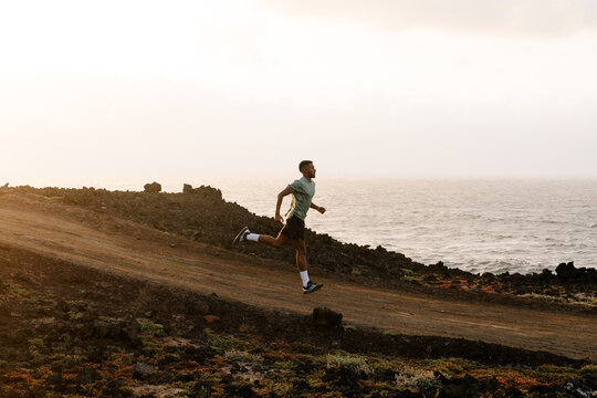 Trail runner training in the distance along a dirt path