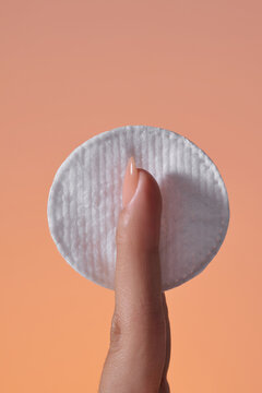 Close-up of a finger holding a cotton pad