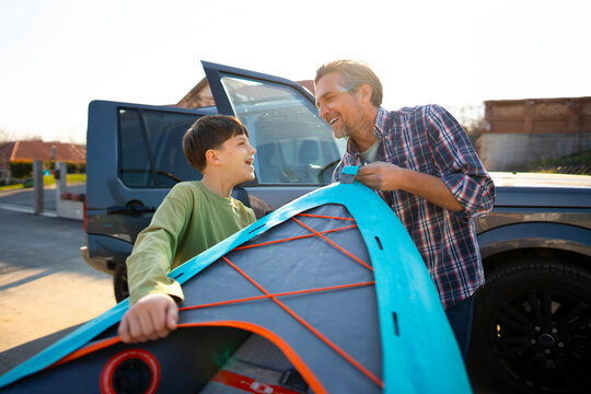 Father and son packing kayak for trip