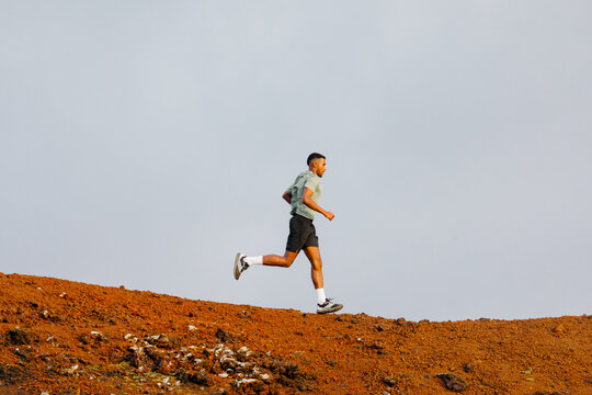 A trail athlete is seen training far along rocky paths
