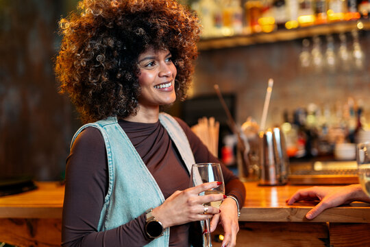 Woman enjoying a drink at a bar socializing