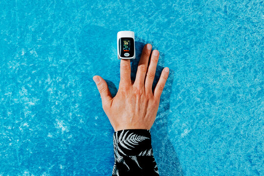 a man places his hand with a pulse oximeter on his finger