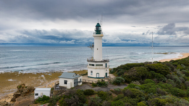 Lighthouse on a coastal cliff in front of an approaching storm front