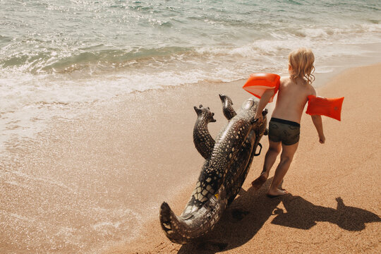 The children are playing in the water with an inflatable crocodile