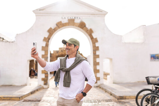 man taking a selfie at the entrance to La Caleta beach in Cadiz