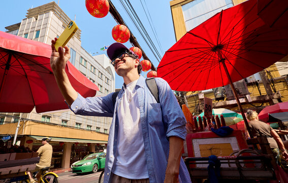 Man taking photo with smartphone in market Bangkok Thailand