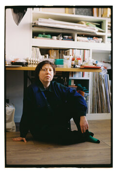 The artist is sitting in his studio.