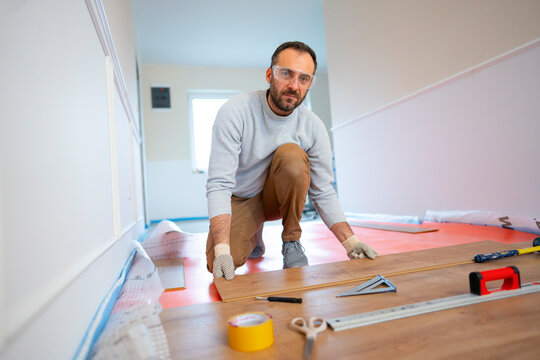 Man works on flooring in a home renovation project