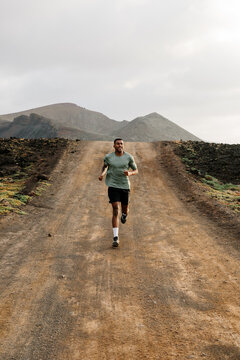 A wide-angle scene shows an elite runner progressing along a dirt path