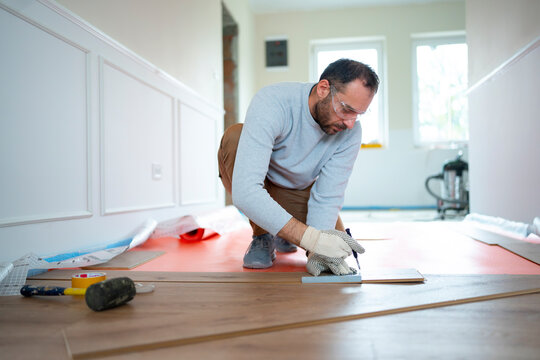 Man installs new flooring in a home setting