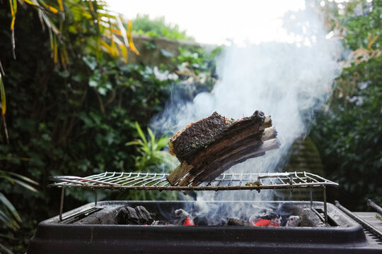 Smoke Rises From Meat on Grill in Garden  Barbecue