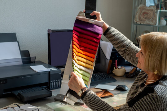 Elderly woman designer working with palette of fabric samples