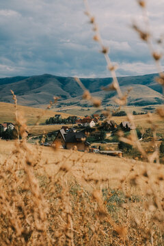 Mountain village framed by dry grass in foreground