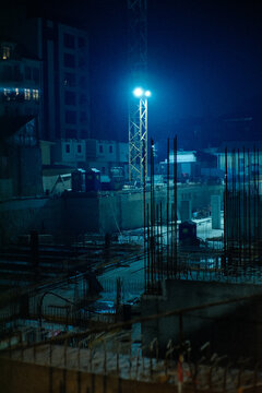 Night construction site lit by bright floodlights