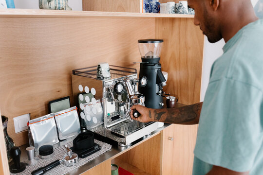 Hardworking man making himself a cup of coffee at home