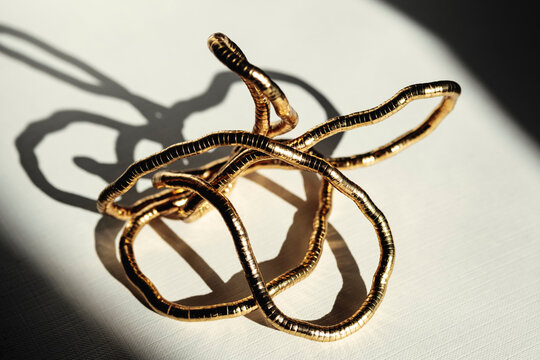 Gold Wire Sculpture on Table With Shadows in Afternoon Light