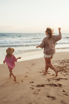 Carefree Mother and Daughter Enjoying Evening Beach