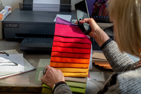 Faceless female designer working with palette of fabric samples