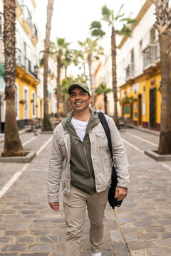 Happy man walking towards the camera on a street in Cadiz, Spain