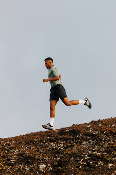 Endurance runner pushes downhill along a rocky mountain track