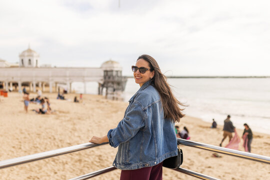 Female tourist arriving at a seafront promenade on a beautiful beach 