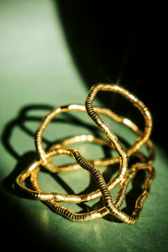 Gold Wire Hoops on Green Surface With Shadows