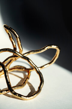 Gold Wire Sculpture on Table With Shadows in Afternoon Light