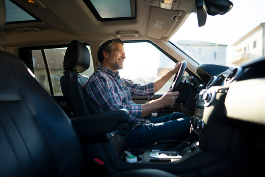 Man driving a car on a bright day