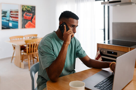 Freelancer handling business calls from his kitchen