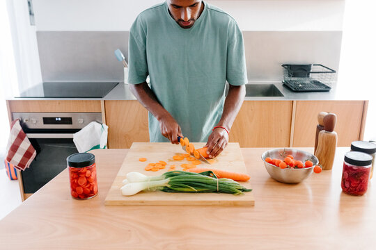 Man manages remote work at home while cooking
