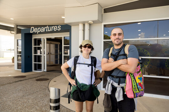 Portrait of couple with backpacks outside Ballina Airport Australia