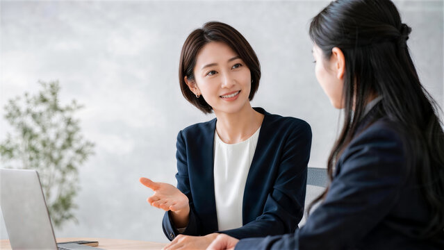 会議室で同僚に説明する女性ビジネスパーソン