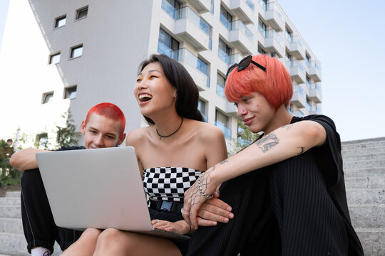 Three students are sitting on the stairs and studying
