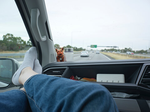 Road Trip Scene With Feet Resting on Dashboard Near Highway