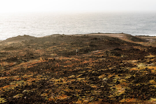 The view reveals a distant runner training across cross-country paths