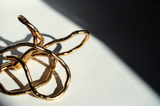 Gold Wire Sculpture on Table With Shadows in Afternoon Light