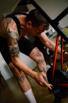 Tattooed Cyclist prepring his indoor bicycle