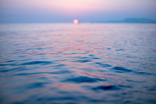 Soft focus sunset over calm sea surface