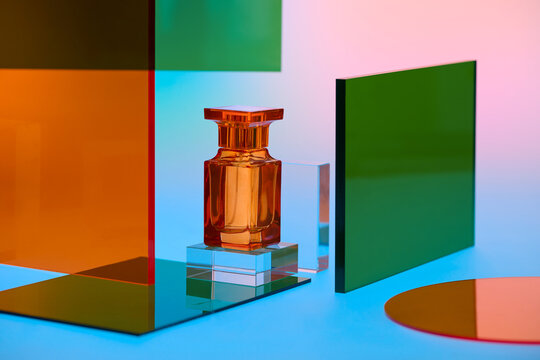 Elegant orange perfume bottle displayed on clear acrylic blocks