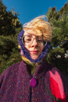 Woman in colorful knit hood and glasses outdoor portrait