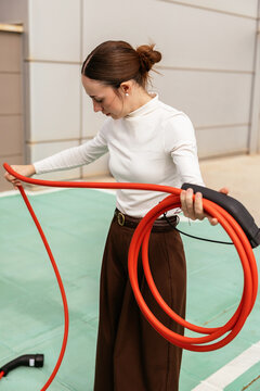 Woman preparing to charge electric car ev cable